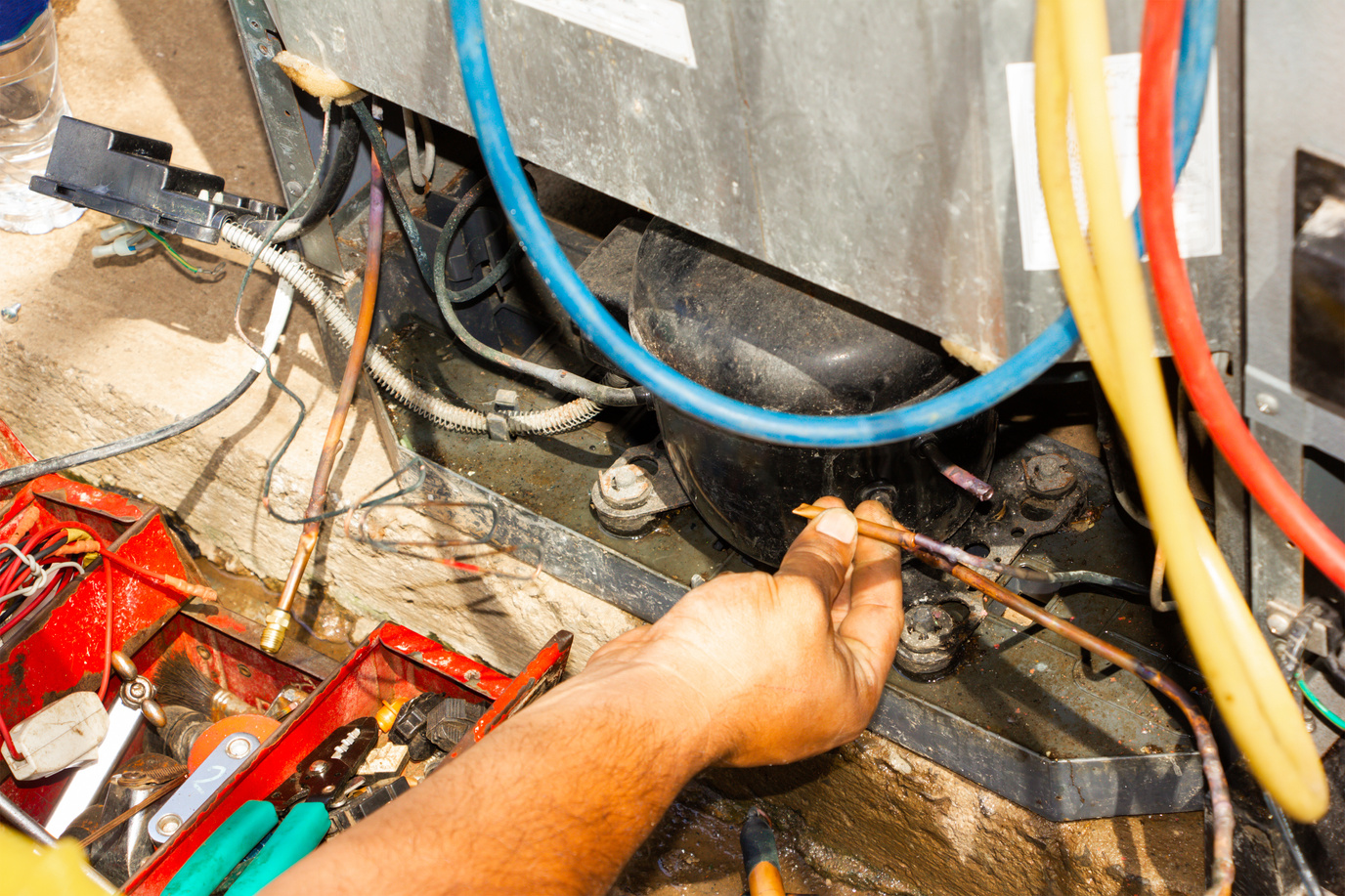 technician repair refrigerator by welding copper pipe and vacuum